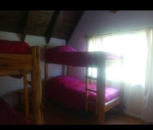 a bedroom with two bunk beds and a window at CABAÑA LA PAZ in Moquehue