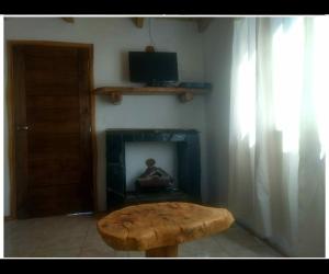 a wooden coffee table in a living room with a fireplace at CABAÑA LA PAZ in Moquehue