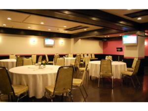 a conference room with tables and chairs and two screens at Shobara Grand Hotel - Vacation STAY 06899v in Shōbara