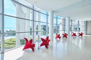 un grupo de sillas rojas en una habitación con ventanas en GRAND NIKKO AWAJI, en Awaji