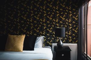 a bedroom with a bed with a black and gold wallpaper at Wattle Terrace in Castlemaine