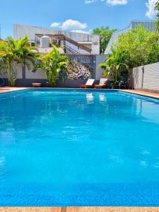 uma grande piscina com água azul em frente a um edifício em Hostel Park Iguazu em Puerto Iguazú