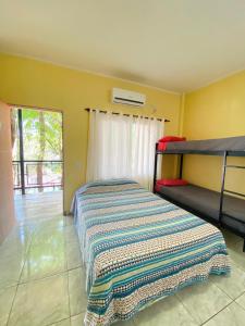 Un dormitorio con una cama con una manta. en Hostel Park Iguazu en Puerto Iguazú