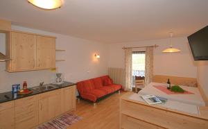 a kitchen and living room with a red couch at Ferienwohnungen Bulandhof in Valdaora