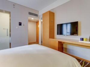 sypialnia z łóżkiem i telewizorem z płaskim ekranem w obiekcie Holiday Inn Express Xi'an High-Tech Zone, an IHG Hotel w mieście Xi'an