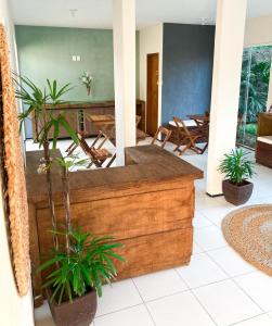 una sala de estar con un banco de madera y plantas en Pousada Porto Rio en Parnaíba