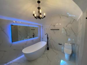 a white bathroom with a tub and a toilet at Siete Puertas Coyoacán in Mexico City
