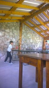 a young boy playing a game of table tennis at Cabañas Alvear in Huerta Grande