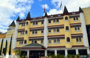 um grande edifício amarelo com torres em Hotel y Restaurante Castillo de los Altos em Quetzaltenango