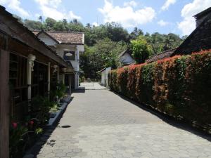 a walkway next to some buildings and a hedge at Hotel Family Syariah 1 in Parangtritis