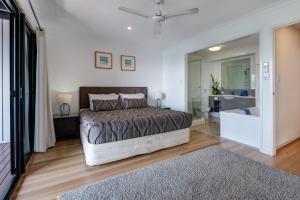 um quarto com uma cama e uma casa de banho com uma banheira em Shorelines Apartments on Hamilton Island by HIHA em Hamilton Island