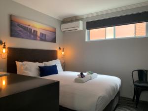 um quarto de hotel com uma cama com um urso de peluche em Merewether Motel em Newcastle