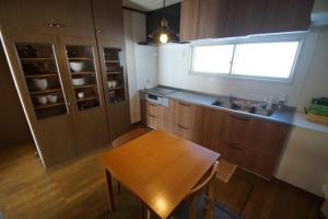 a kitchen with a wooden table and a window at Farm Stay Ezura Farm in Engaru