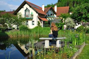 a girl sitting on a bench in front of a house at Mosthäusl in Wernstein am Inn