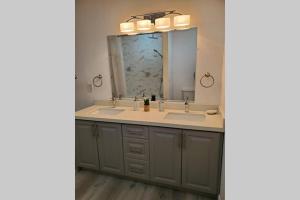 a bathroom with two sinks and a large mirror at Cottage with River Front & minutes away from Beach in Wasaga Beach +49 photos