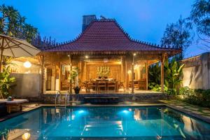 a villa with a swimming pool and a house at PNB Bali Villas in Canggu