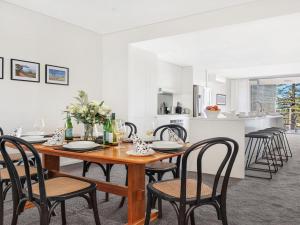 a kitchen and dining room with a wooden table and chairs at Bathers at the Beach in Kiama