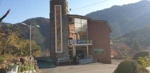 ein Gebäude mit einem Turm mit einem Berg im Hintergrund in der Unterkunft Seoraksan BanDalGom in Sokcho