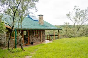 uma pequena casa de pedra com um telhado verde em Honeymoon Hut em Naivasha