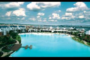 a large swimming pool in front of a resort at The Blyde, Crystal Lagoon One Bed Apartment. in Pretoria