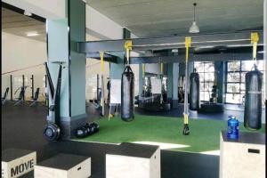 a gym with lots of gym equipment and weights at The Blyde, Crystal Lagoon One Bed Apartment. in Pretoria