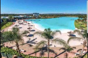 a view of a beach with umbrellas and a pool at The Blyde, Crystal Lagoon One Bed Apartment. in Pretoria