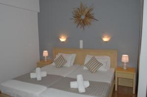 sypialnia z dużym łóżkiem z białą pościelą i poduszkami w obiekcie Rania Studios w mieście Skiatos