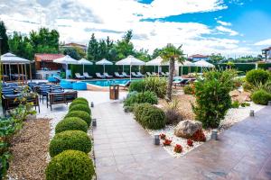 a patio with a pool and tables and chairs at Lagaria Apartments in Afitos