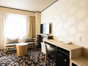 a hotel room with a desk and a television at Maizuru Grand Hotel in Maizuru