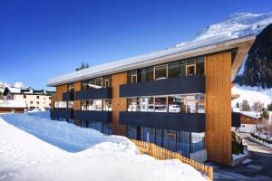 a building in the snow with mountains in the background at Apart6580 in Sankt Anton am Arlberg