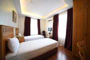 um quarto de hotel com duas camas e janelas em Park Star Hotel Taksim em Istambul