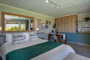 a bedroom with a bed and a table in a room at Wildlife Retreat on a Wine-Farm in Stellenbosch