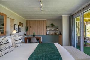 um quarto com uma cama grande e uma mesa em Wildlife Retreat on a Wine-Farm em Stellenbosch