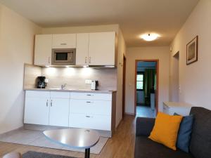 a kitchen and living room with a couch and a table at Mare Balticum Urlaub auf Rügen in Sagard
