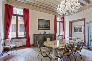 a dining room with a table and chairs and a chandelier at Doge Palace Luxury Apartment - Cannaregio in Venice