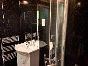 La salle de bains est pourvue d'un lavabo et d'une douche. dans l'établissement Chase the Wild Goose, by Fort William, à Fort William