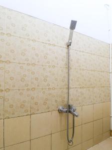 a shower in a bathroom with a tile wall at RedDoorz At Merdeka Street Garut in Garut +8 photos