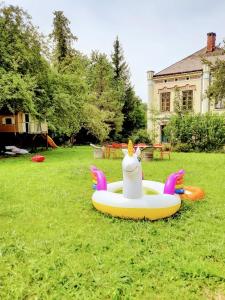 Ein aufblasbares Spielzeug eines Huhns sitzt auf dem Gras in der Unterkunft Sisi-Schloss Rudolfsvilla - Appartement Gisela in Reichenau