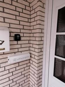 uma parede de tijolos ao lado de uma porta com uma caixa de correio em Haus Peters em Stadtoldendorf