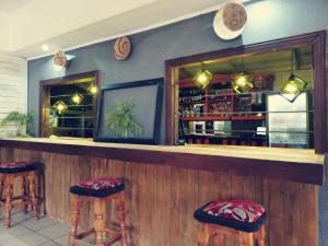 a bar with stools in a room with a counter at Riverside's Kaia in Calcutta