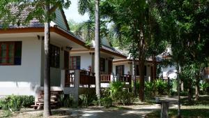 a house with palm trees in front of it at Resort Railumpoo (Farm and Camping) in Nakhon Sawan