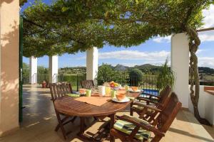 a wooden table and chairs on a patio at Son Rotger, villa Tía Catalina con piscina en Alcudia in Alcudia