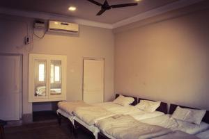2 Betten in einem Zimmer mit Fenster in der Unterkunft Hotel Anand Palace in Gwalior