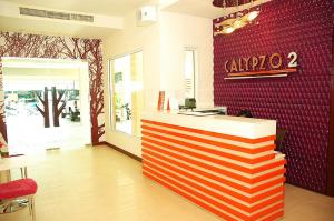 a restaurant with a counter and a red wall at Calypzo 2 Ratchada 20 in Bangkok