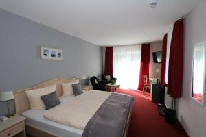 a hotel room with a bed and a living room at Hotel Ännchen in Bad Neuenahr-Ahrweiler