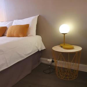 un letto con una lampada su un tavolo accanto ad esso di Hôtel Bellevue Cannes a Cannes