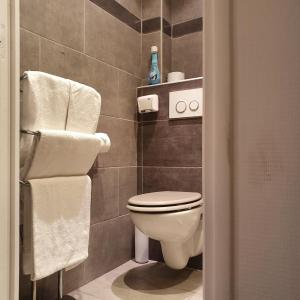 a bathroom with a toilet and towels in it at Hôtel Bellevue Cannes in Cannes