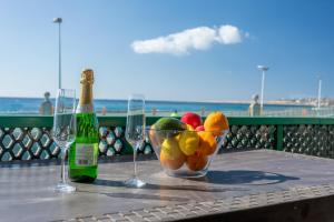 Una mesa con un bol de fruta y dos copas de vino. en Las Burras Beach terrace&pool By CanariasGetaway, en San Agustín