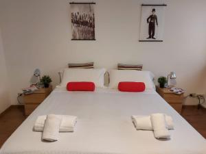 un grande letto bianco con asciugamani rossi e bianchi di Bnbook-Ughelli a Rho