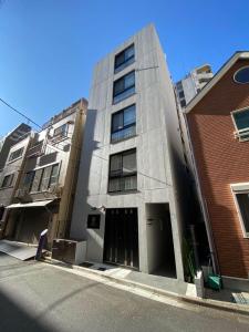 un immeuble de grande hauteur au bord d'une rue dans l'établissement nestay apartment tokyo ginza, à Tokyo
